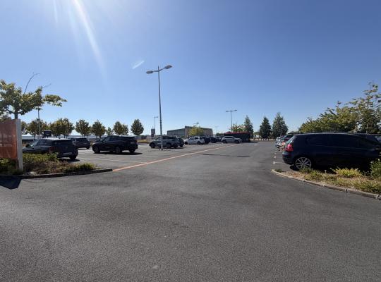 Zone de stationnement extérieure du parking P2 avec voitures garées sous le soleil.