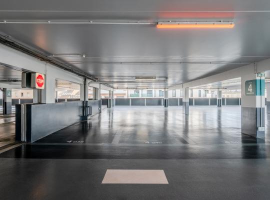 Emplacements numérotés et allée de circulation couverte au niveau 4 du parking.