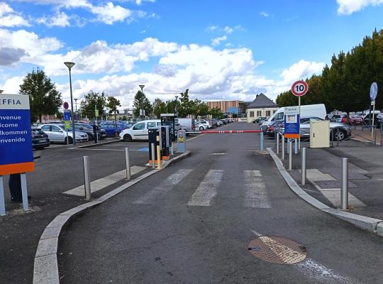 Voies d'accès et d'entrée du parking extérieur avec barrières automatiques.