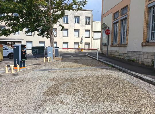 Voie de sortie du parking avec barrière automatique et borne de validation.