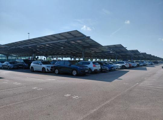 Zone de stationnement extérieure protégée par de grandes ombrières photovoltaïques à Valence TGV.
