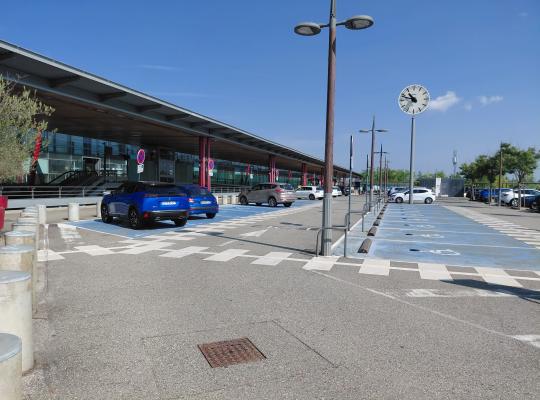 Emplacements bleus réservés PMR et dépose-minute situés juste devant le hall de la gare.