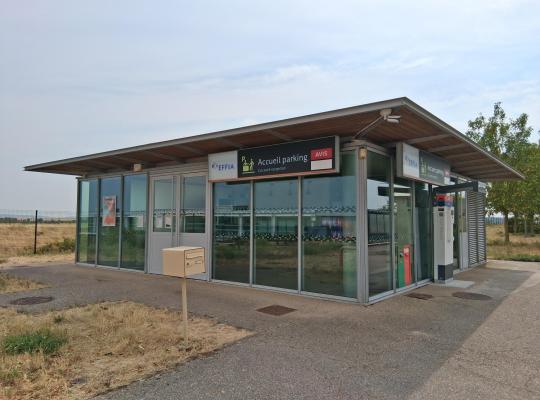 Bâtiment moderne vitré abritant l'accueil du parking EFFIA et un comptoir AVIS, de plain-pied avec une boîte aux lettres à l'extérieur.