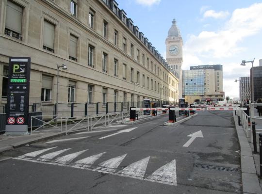 Entrée du parking Dépose-Minute EFFIA à la Gare de Lyon, avec panneau d'affichage des tarifs et vue sur la célèbre tour de l'horloge.