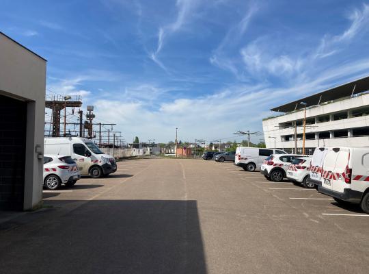 Zone de stationnement extérieure bordée par les voies ferrées et le parking à étages EFFIA.