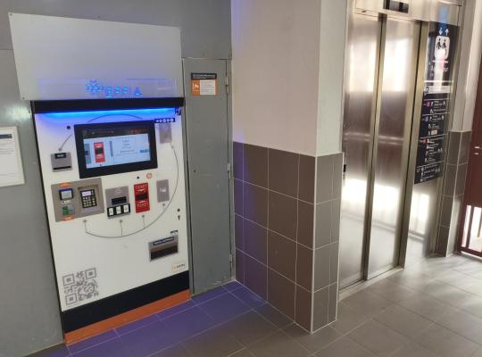 Caisse automatique de paiement EFFIA en intérieur près d'un ascenseur.