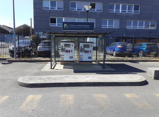 Caisses automatiques de paiement sous abri vitré sur le parking de la gare.