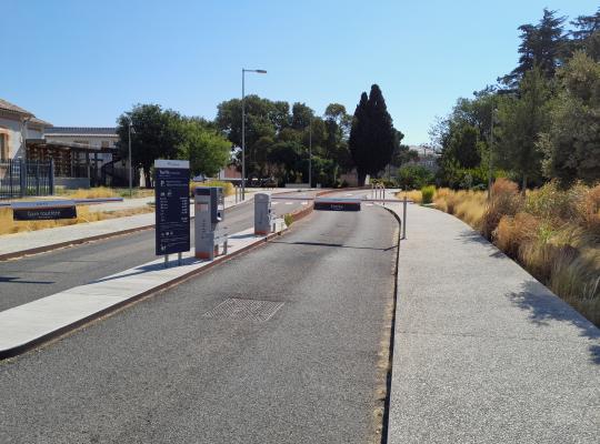 Entrée de la zone dépose-minute EFFIA équipée de barrières automatiques et d'un panneau d'information tarifaire.