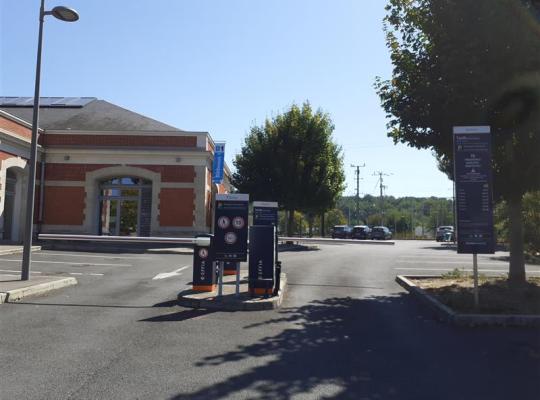 Bornes de contrôle d'accès, barrières automatiques et panneaux d'information à l'entrée du parking.