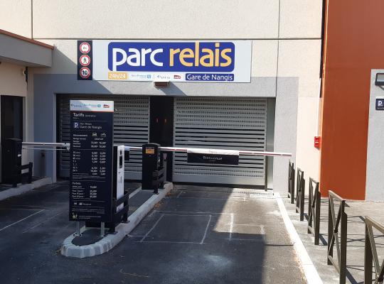 Entrée du parking Parc Relais Gare de Nangis avec bornes de contrôle, barrières et panneau d'affichage des tarifs.