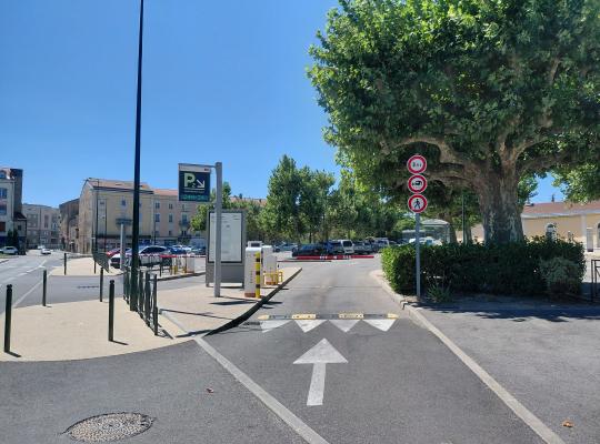 Voie d'accès au parking P2 équipée d'une signalétique lumineuse, de bornes d'entrée et d'une barrière automatique.