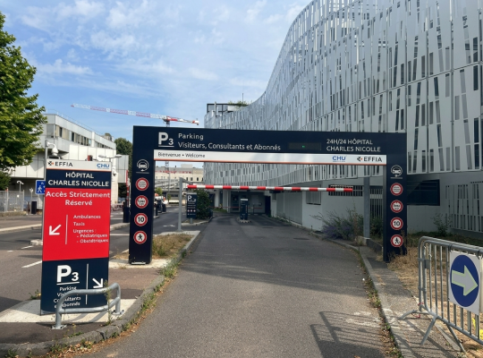 Entrée du parking P3 de l'Hôpital Charles Nicolle, géré par EFFIA, ouverte 24h/24. Un grand portique de signalétique noir indique "Parking Visiteurs, Consultants et Abonnés". Un panneau rouge distinct précise "Accès Strictement Réservé" avec des logos de services d'urgence.