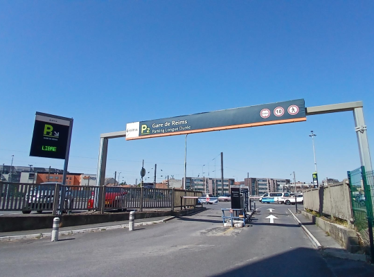 Portail d’accès, barrière automatique et portique de signalisation à l’entrée du parking.
