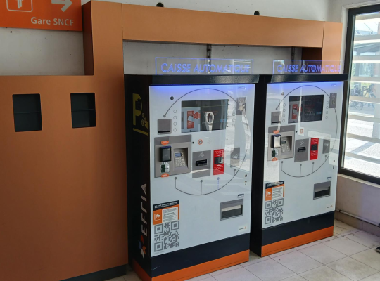 Caisses automatiques de paiement situées à l'intérieur de l'espace d'accueil du parking.