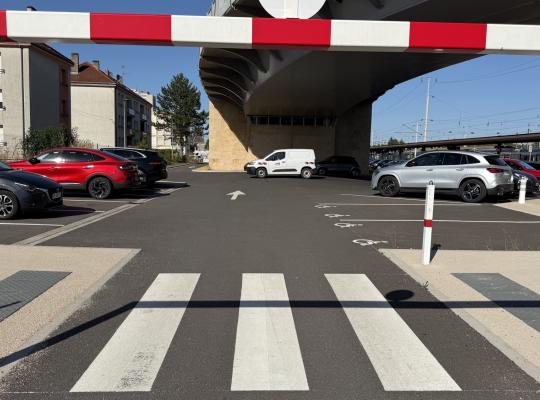 Emplacements de stationnement réservés aux personnes à mobilité réduite situés sous un pont routier.