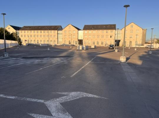 Vue d'ensemble du parking à découvert situé sur le toit-terrasse face aux bâtiments du Centre Colbert.