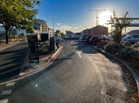Voie d'accès au parking EFFIA avec totem d'affichage des tarifs et barrière automatique.