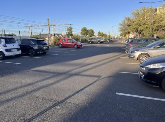 Zone de stationnement extérieure du parking longue durée, située le long des voies ferrées.