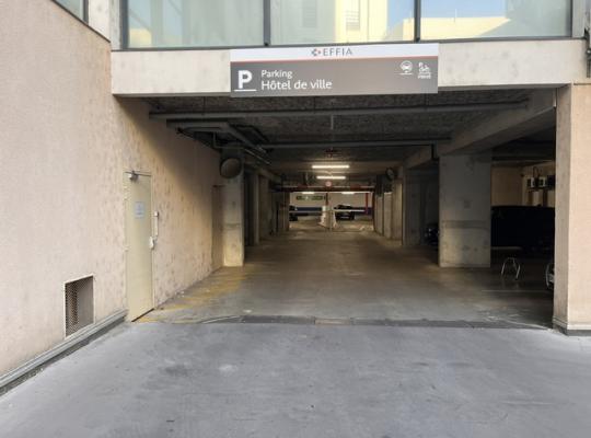 Entrée couverte du parking EFFIA Hôtel de Ville avec panneau de signalisation et barrière d'accès.