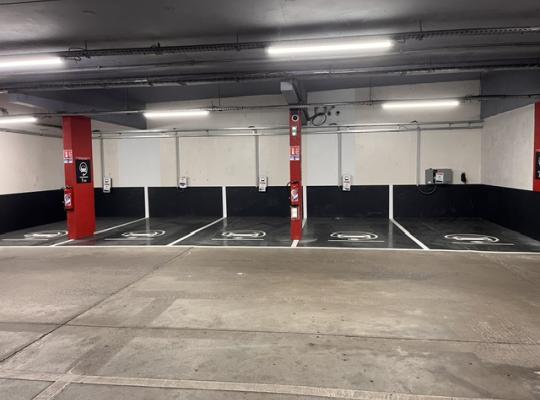 Emplacements réservés à la recharge des véhicules électriques équipés de bornes murale et marquage au sol.