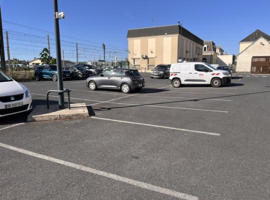 Emplacements de stationnement extérieurs à découvert avec marquage au sol.