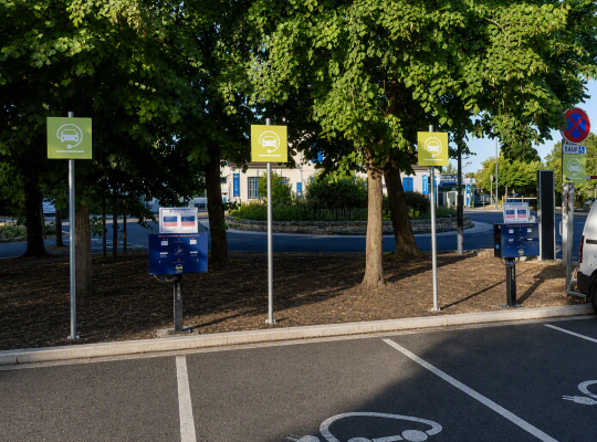 Places réservées à la recharge des véhicules électriques avec panneaux signalétiques et bornes de charge.