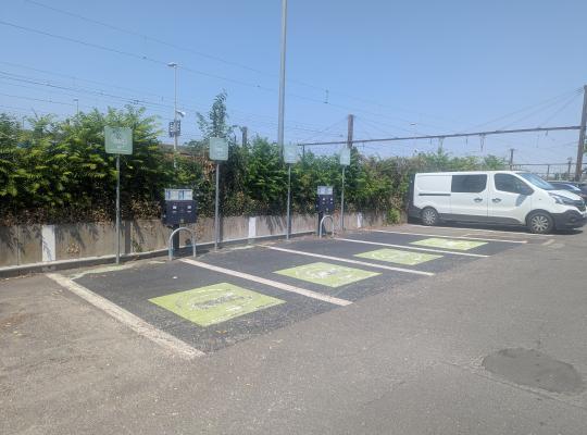 Quatre places avec marquage au sol et bornes de recharge pour véhicules électriques.