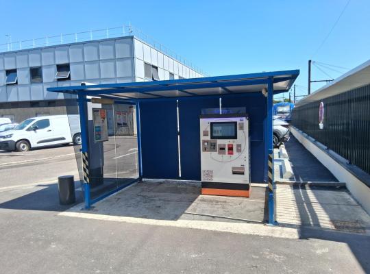 Caisse automatique de paiement EFFIA installée sous un abri métallique bleu.