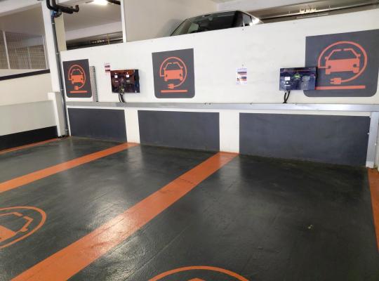 Emplacements de stationnement réservés aux véhicules électriques avec bornes de recharge murales.