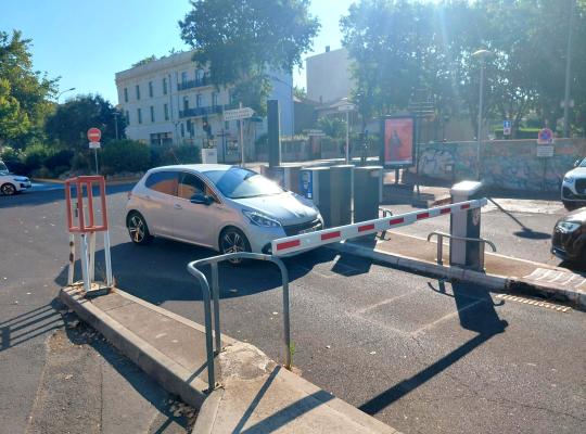 Bornes d’entrée et barrière automatique régulant l’accès aux véhicules.
