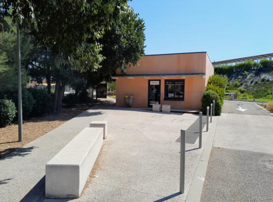 Local d'accueil EFFIA et parvis aménagé avec des bancs en béton devant le parking P1.