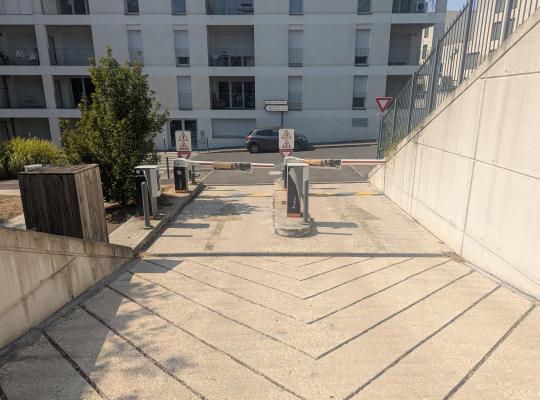 Rampe de sortie en pente équipée de deux barrières automatiques.