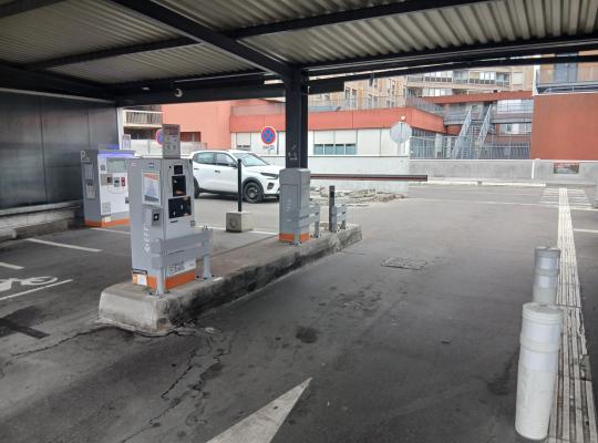 Zone de sortie couverte avec bornes de péage, caisse de paiement et barrière automatique.