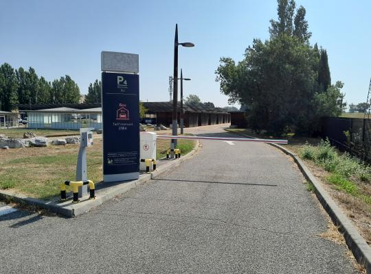 Panneau tarifaire d'abonnement, borne d'accès et barrière automatique à l'entrée du parking EFFIA P4.