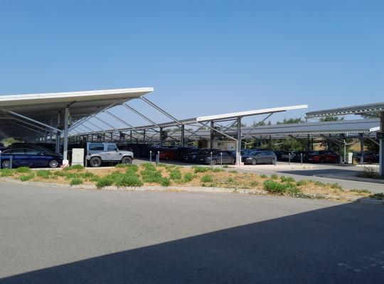 Emplacements de stationnement protégés sous des ombrières métalliques au parking EFFIA P7.