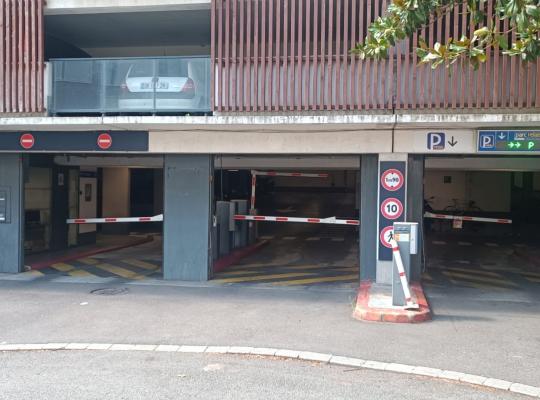 Voies d'entrée et de sortie du parking couvert avec barrières automatiques.