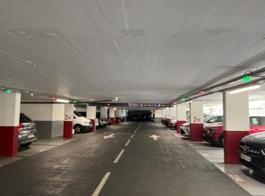Allée centrale du parking couvert avec voyants lumineux de disponibilité des places.