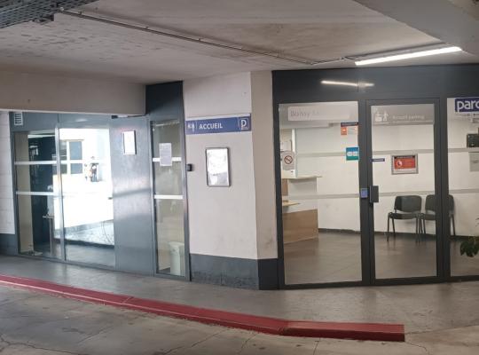 Espace d'accueil et bureau du parc relais derrière des baies vitrées.