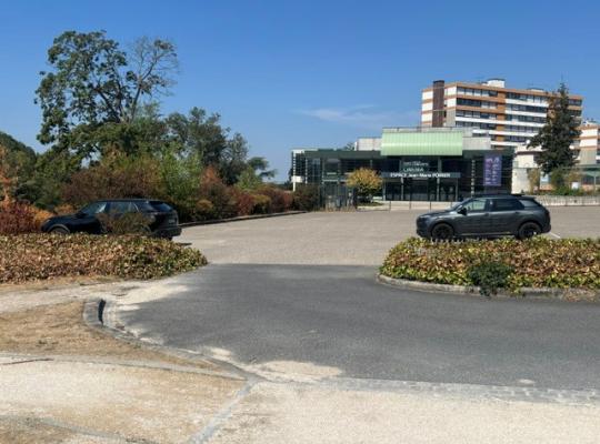 Vue sur le parking extérieur devant le bâtiment Espace Jean-Marie Poirier.