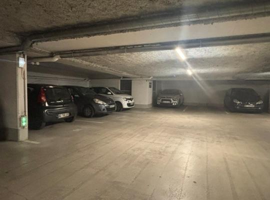 Voitures garées sur des emplacements dans un parking souterrain éclairé.