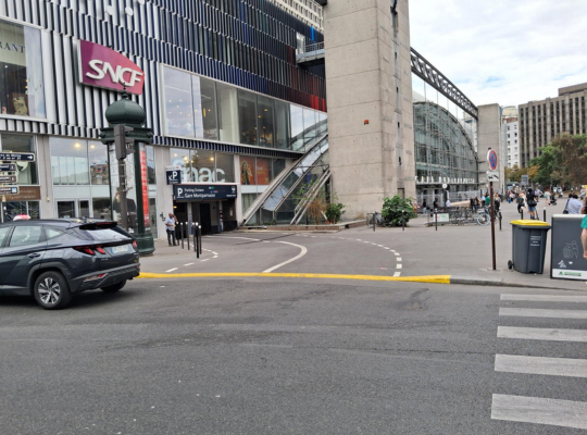 Entrée du parking couverte située au pied de la gare Montparnasse et des commerces adjacents.