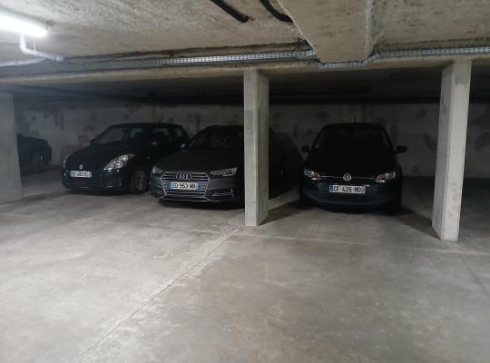 Voitures de différentes marques stationnées en marche arrière dans un parking couvert.