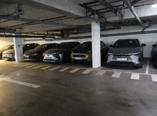 Rangée de voitures stationnées dans un parking souterrain éclairé.