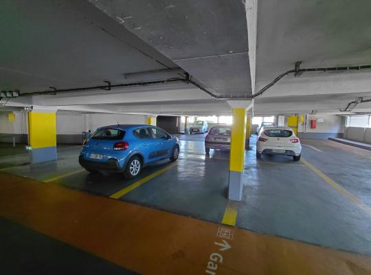 Places de stationnement intérieures avec cheminement piéton orange vers la gare.