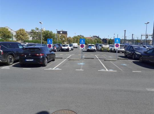 Emplacements de stationnement réservés aux personnes à mobilité réduite avec signalisation dédiée.