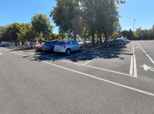 Emplacements de stationnement extérieurs sous les arbres au parking de la gare.
