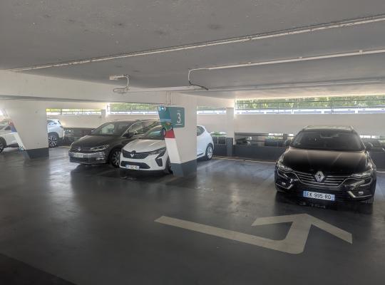 Places de stationnement couvertes au niveau 3 avec plusieurs voitures garées.