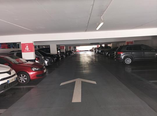 Allée de circulation du niveau 4 bordée de voitures garées de chaque côté.
