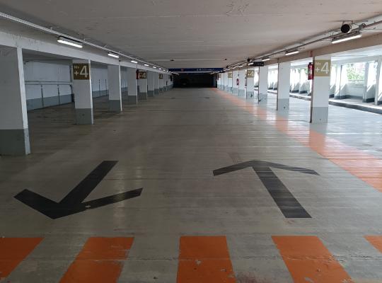 Places de stationnement couvertes au niveau +4 avec marquages au sol et voies de circulation.