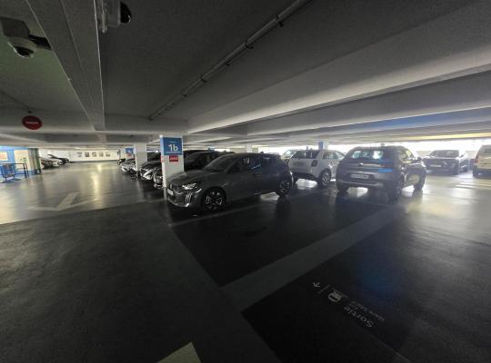 Voie de circulation couverte et places de stationnement au niveau 1b du parking.
